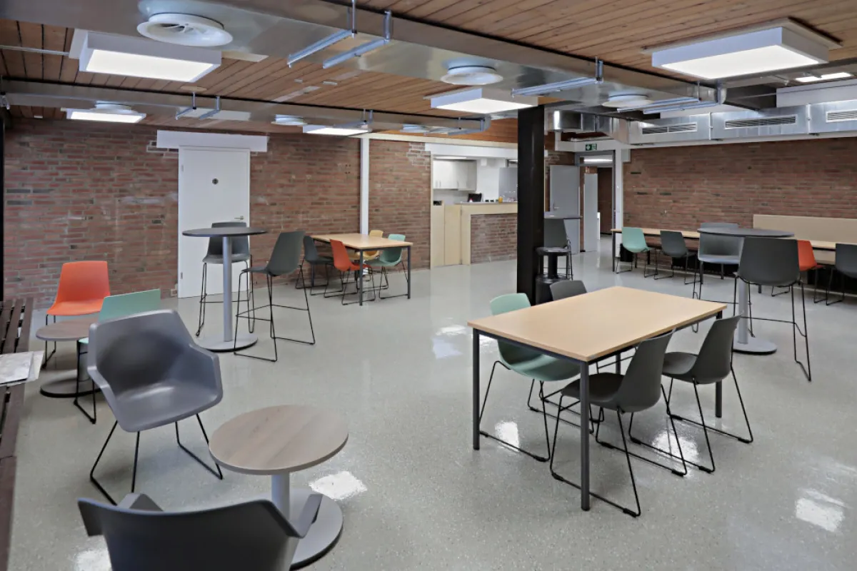 Blick in den Tagestreff Café Pause mit Küchenbereich im Hintergrund