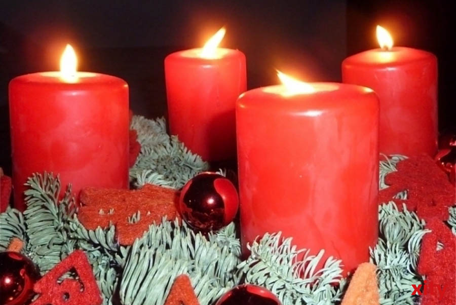 Adventskranz mit vier brennenden Kerzen