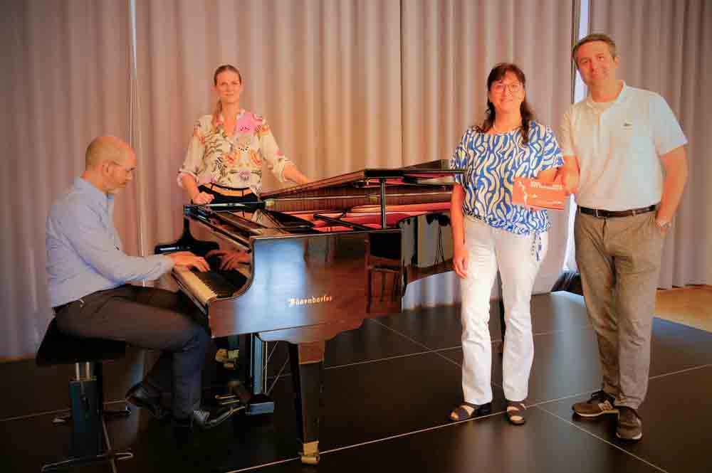 Am Flügel sitzt Generalmusikdirektor Rasmus Baumann und spielt für Marion Freitag, Elke Kappen und Philipp Reckermann