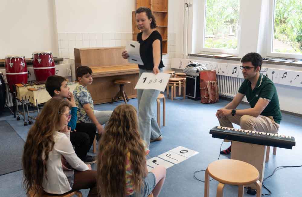 Die Musikpädagogen Debora Buschmann und Francisco Chaves im Unterricht mit vier Schülern in der Bodelschwingh-Schule