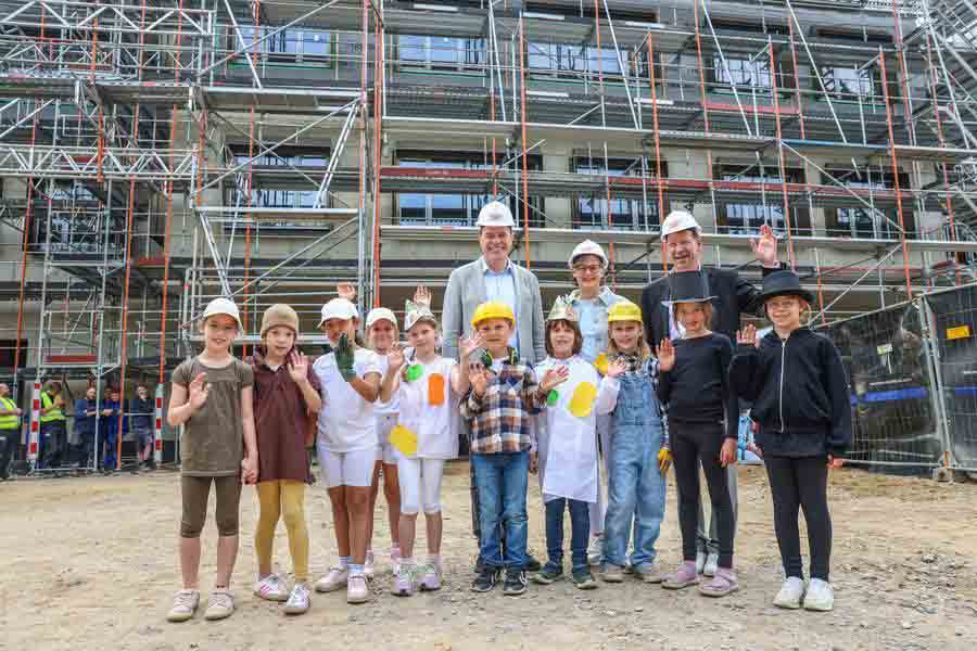 Oberbürgermeister Dr. Stephan Keller, komm. Schulleiterin Susanne Schulz-Isenbeck und Stadtdirektor Burkhard Hintzsche mit Schülerinnen und Schülern der 2a.