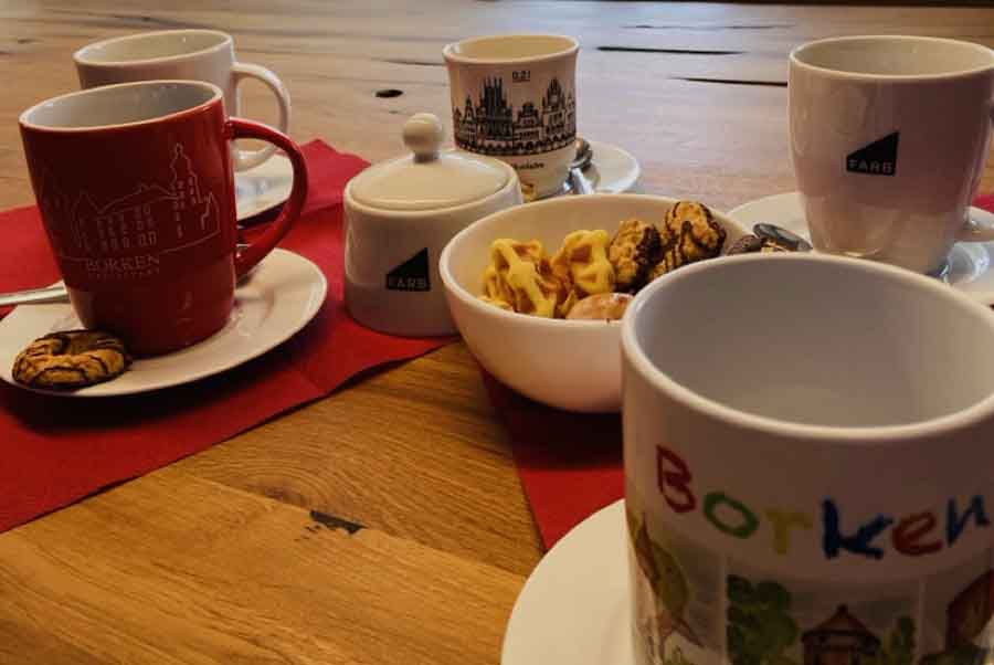 Tisch mit Kaffeetassen und Gebäck