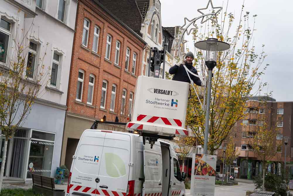 Stadtwerke-Mitarbeiter Marcus Jurick bringt die Weihnachtsbeleuchtung an den Laternen an