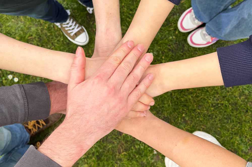 Hände im Kreis übereinander gelegt