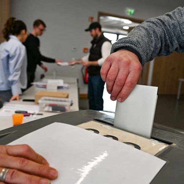 Wahlzettel wird in Urne gesteckt