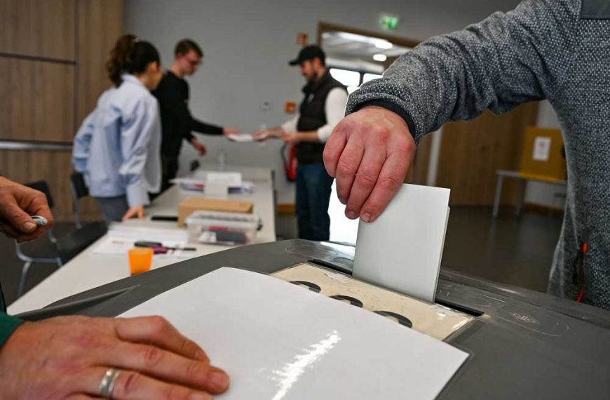 Wahlzettel wird in Urne gesteckt