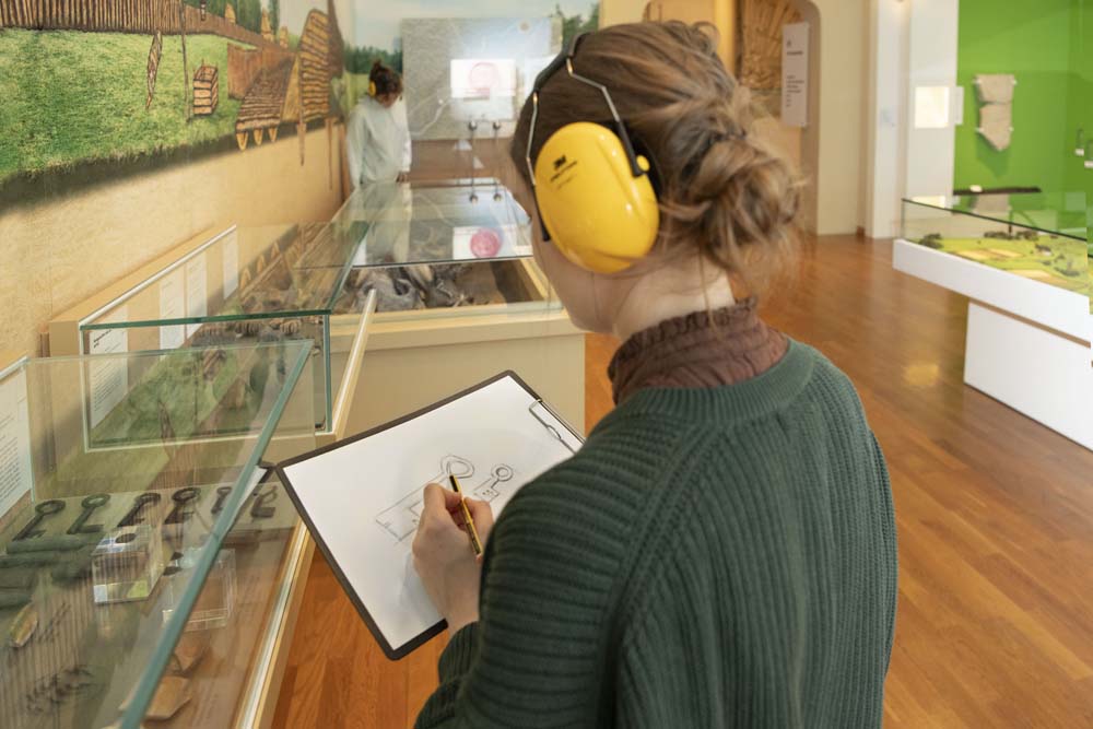 Frau mit Gehörschutz zeichnet