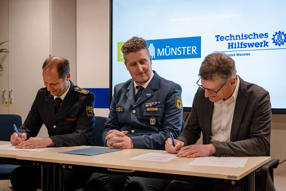 Oberbürgermeister Tilman Fuchs (r.), Gottfried Wingler-Scholz (l.), Leiter des Amtes für Bevölkerungsschutz, Feuerwehr und Rettungsdienst, bei der Unterzeichnung der Vereinbarung mit Bastian Solke, Ortsbeauftragter des THW-Ortsverbandes Münster