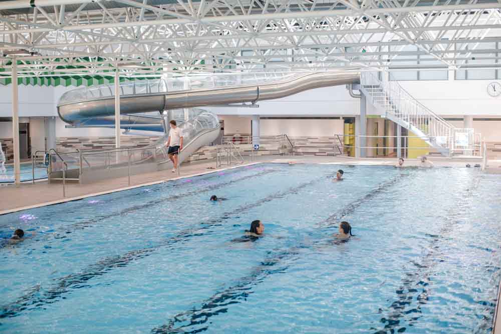 Menschen schwimmen im Hallenbad Kinderhaus