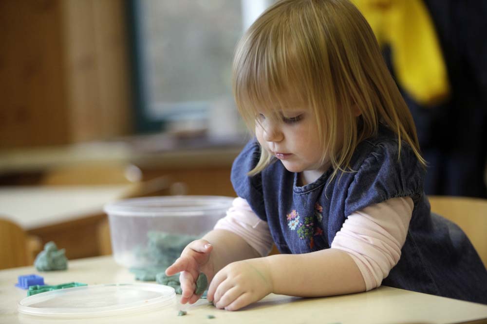 Kind bastelt mit Knete