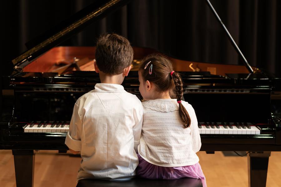 Kinder sitzen am Klavier