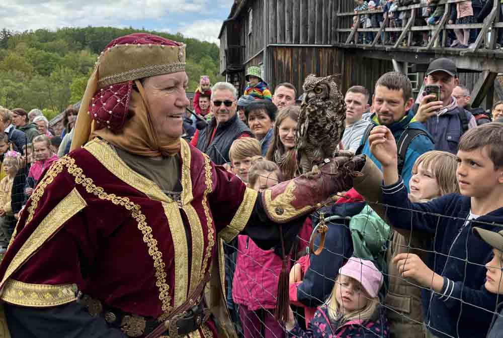 Frau präsentiert dem Publikum einen Falken