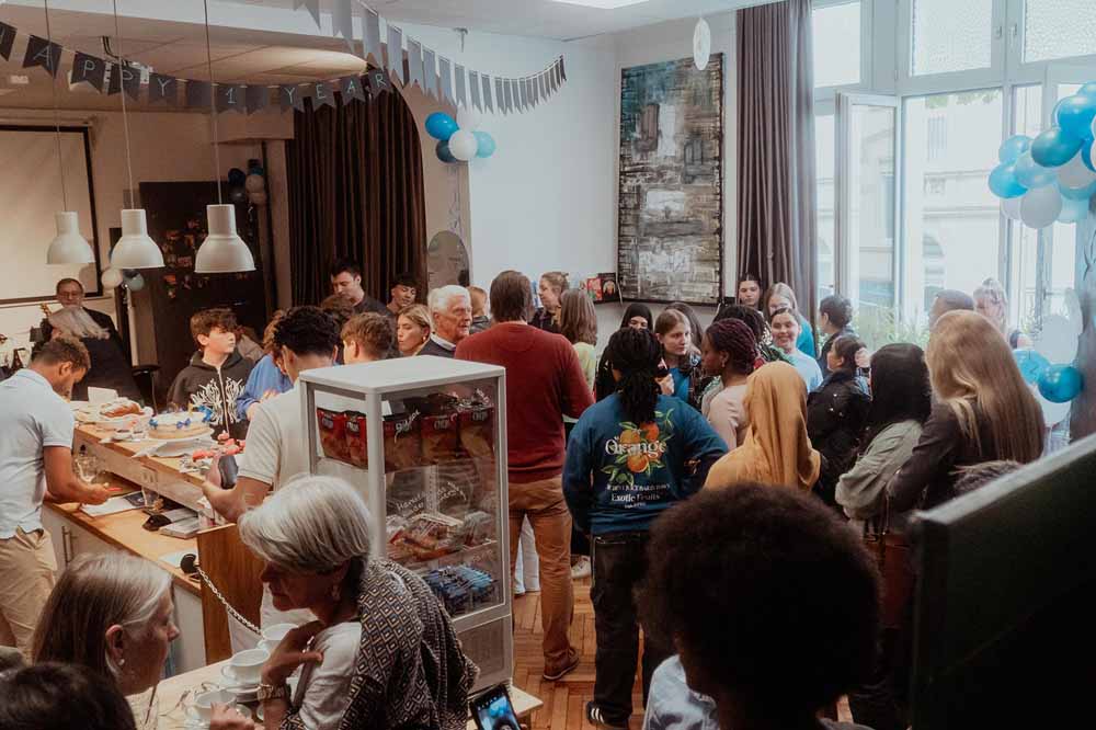Menschen beim einjährigen Jubiläum des Jugendkulturcafé YOU