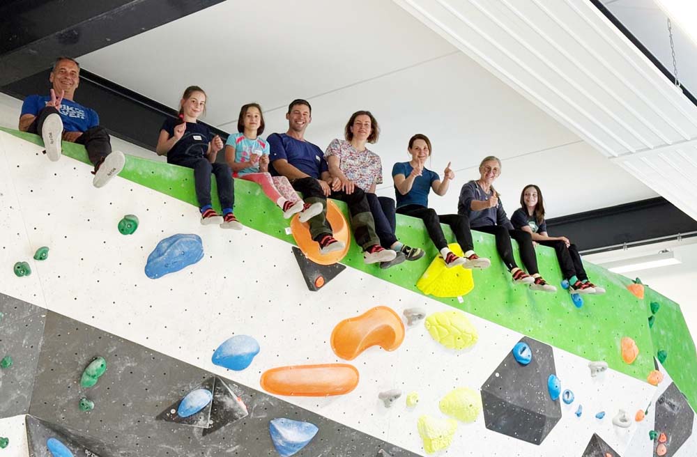 Gruppe sitzt auf Kletterwand