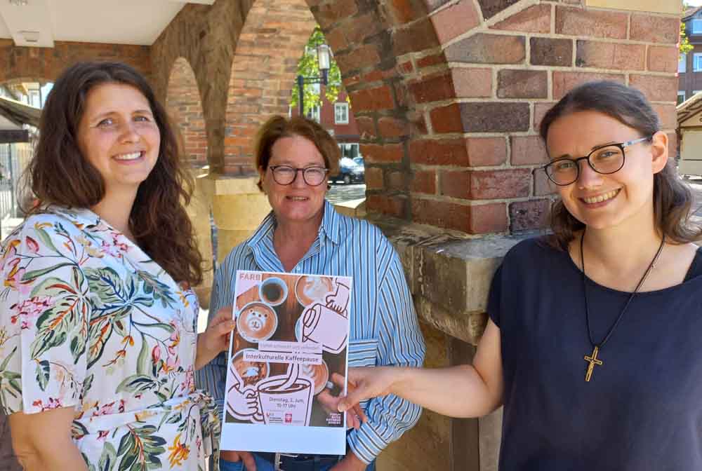 Frauen stellen den Programmflyer vor