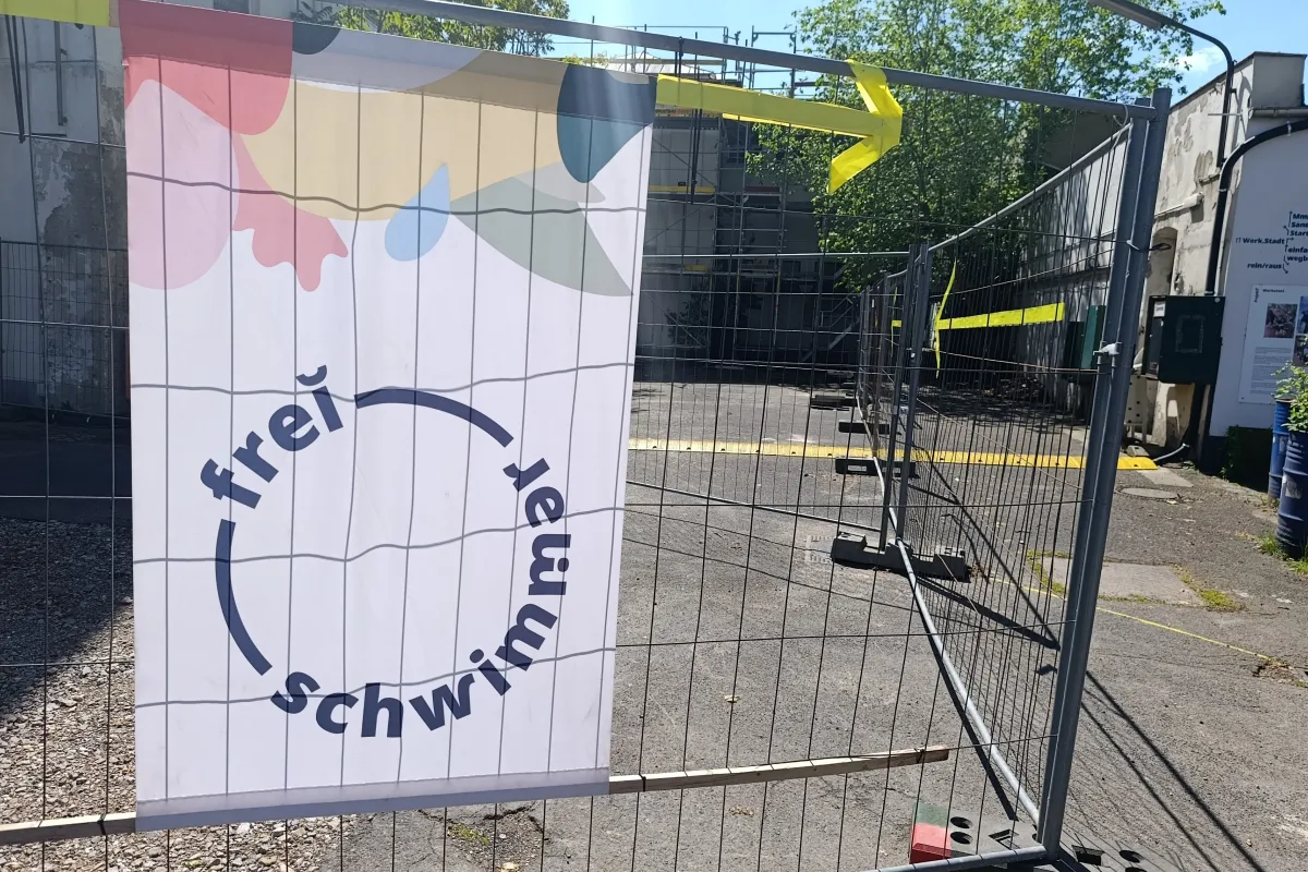 Bauzaun mit Baustelle im Hintergrund