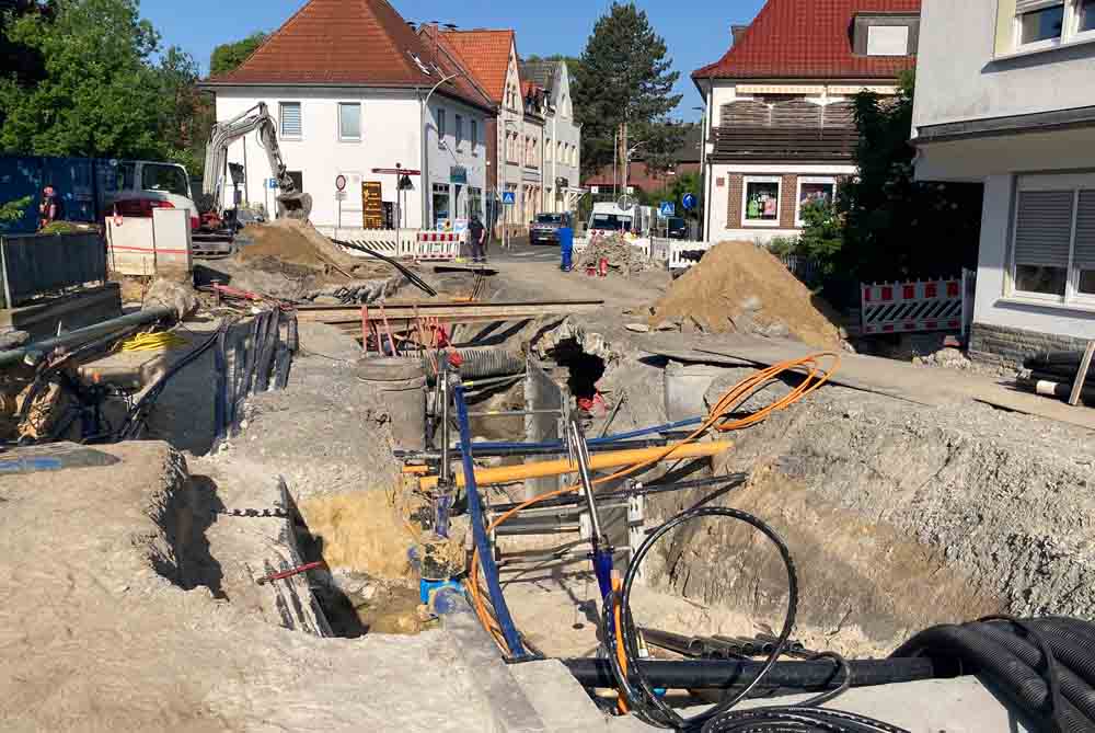 Blick auf den aktuellen Stand der Arbeiten - Baugrube mit Versorgungsleitungen