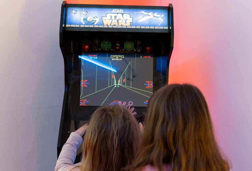 Zwei Kinder spielen am Arcade Automat