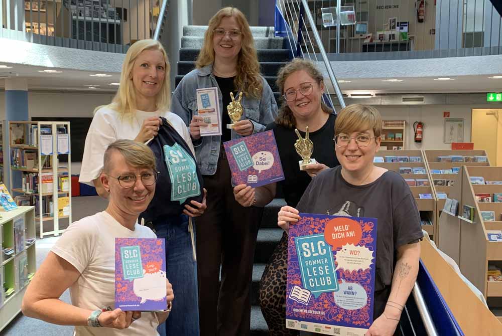 Das Team der Kinder- und Jugendbibliothek mit Plakaten
