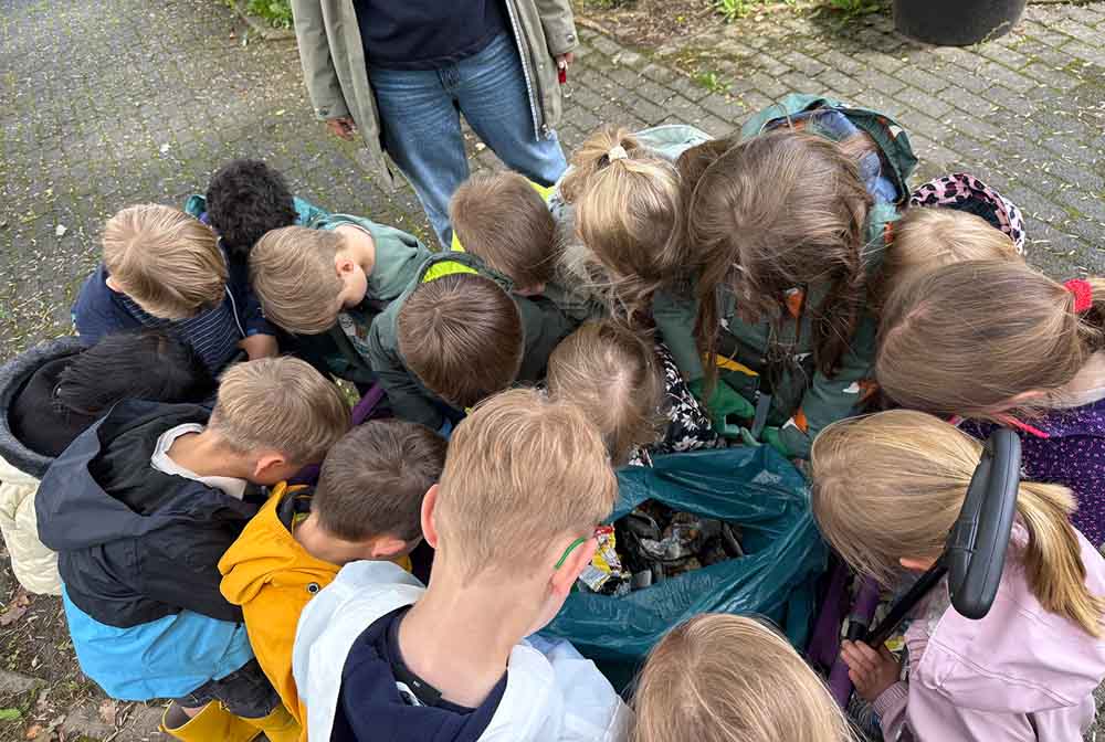 Kinder begutachten gesammelten Müll