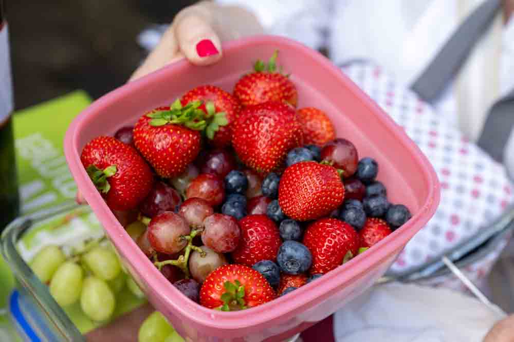 Frau hält Schale mit Früchten