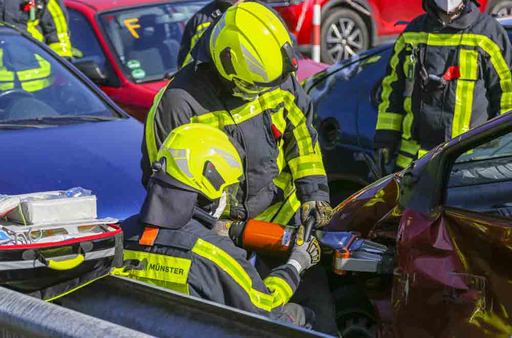 Feuerwehrleute öffnen Autotür mit schwerem Gerät