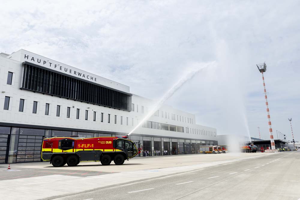 Wasserfontänen aus zwei Panther-Löschfahrzeugen vor dem neuen Einsatzgebäude