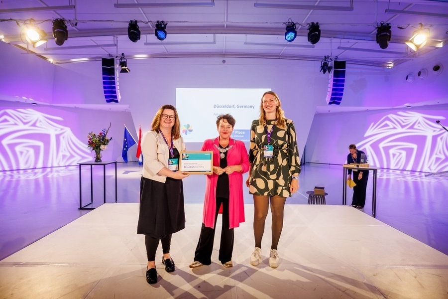 Bei der Preisverleihung der Eurocities Awards 2026 (v.l.): Jessica Breitkopf, Leiterin des Büros für Internationale und Europäische Angelegenheiten, Bürgermeisterin von Utrecht, Sharon Dijksma, und Clarissa Loch, stellvertretende Sachgebietsleitung Beratung und Hilfen für Obdachlose im Amt für Migration und Integration
