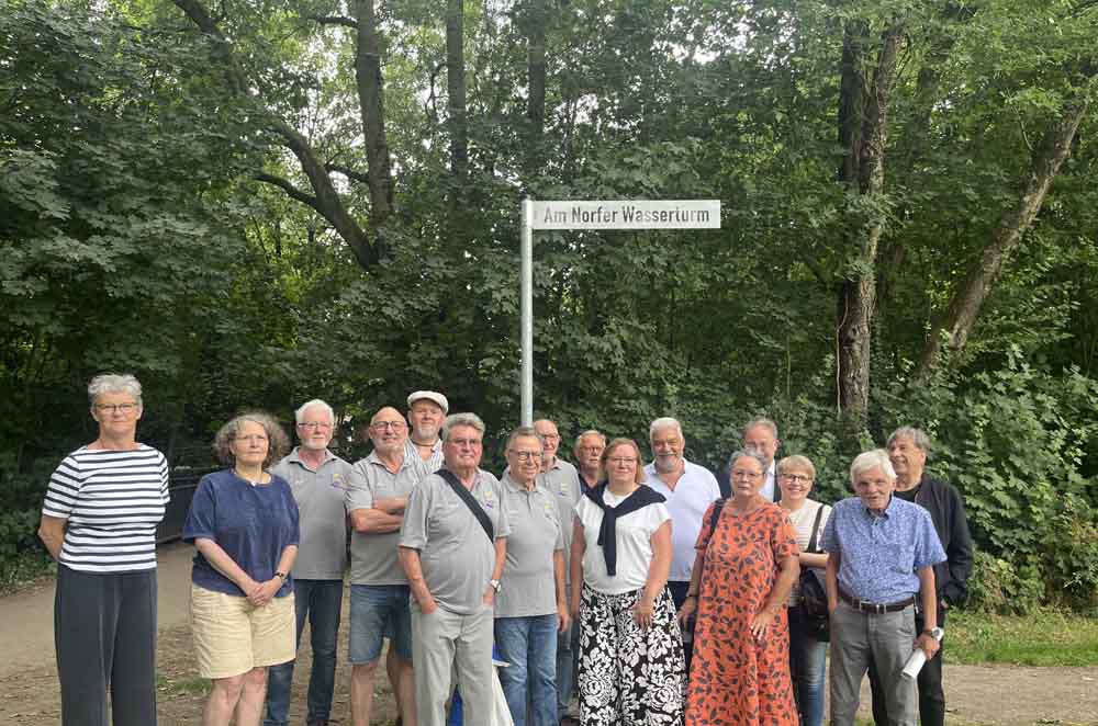 Enthüllung des Schildes "Am Norfer Wasserturm" mit Teilnehmenden