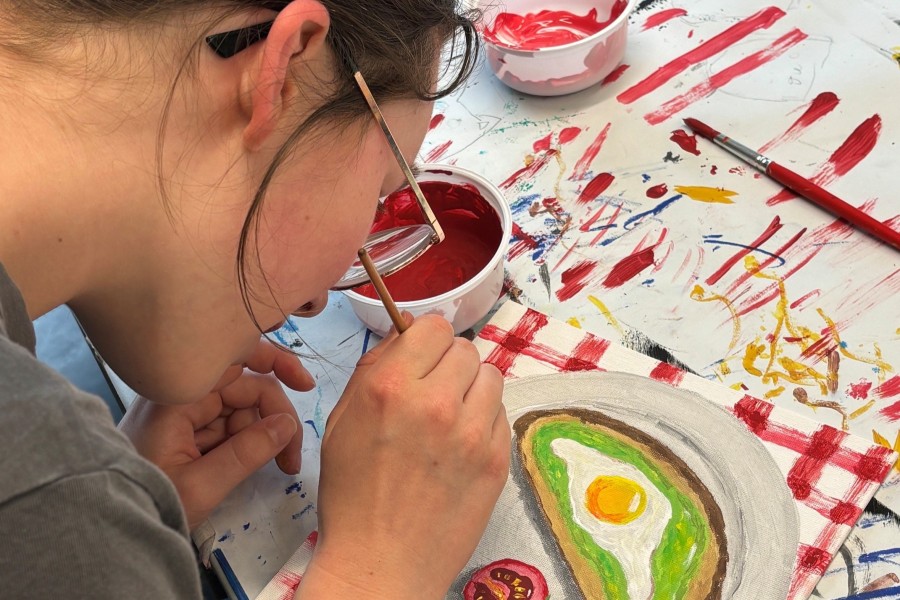 Jugendliche malt mit Farben
