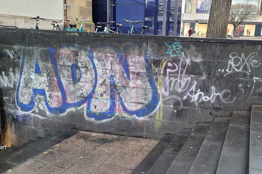 Graffiti an einer Wand neben einer Treppe