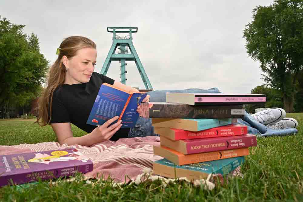 Eine Frau liest vor dem Förderturm des Deutschen Bergbau-Museums am 09.07.2026 ein Buch
