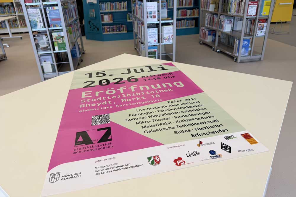 Plakat zur Eröffnung liegt auf einem Tisch