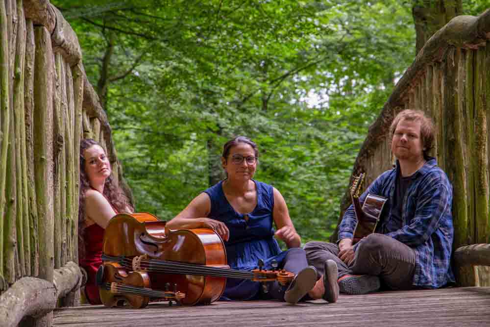 Trio Elderland sitzt auf einer Holzbrücke