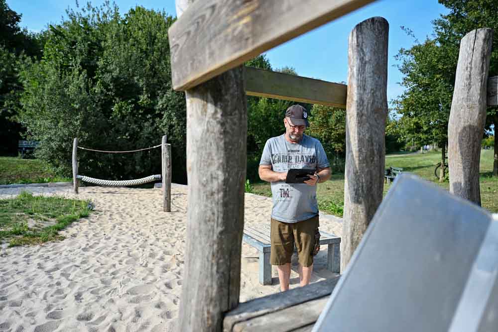 Mann überprüft Spielgerät auf Sicherheit