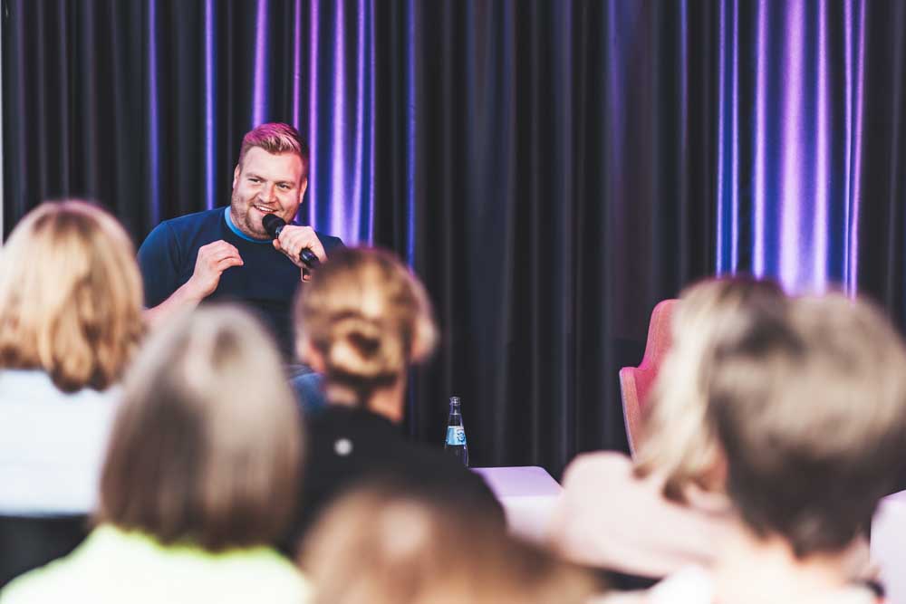 Tobias Beitzel auf der Bühne mit Publikum im Vordergrund