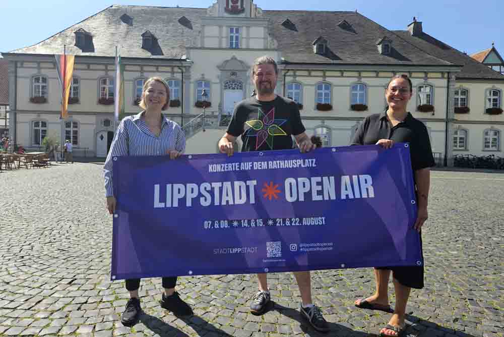Anna Katz, Fachbereichsleitung Kultur und Bildung, Michael Langewender, Tonetoaster GmbH und Kulturmanagerin Ina Lange halten ein Banner