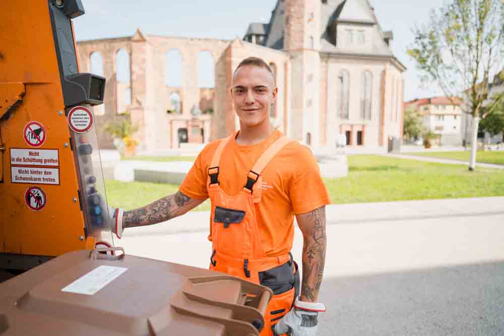 Mitarbeiter der Müllabfuhr am Fahrzeug