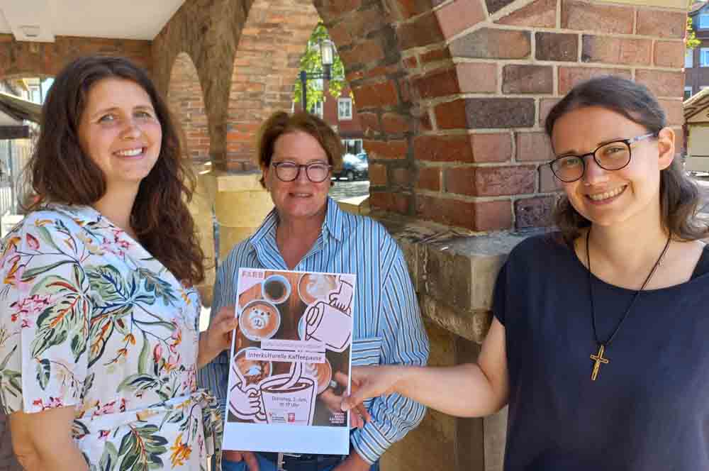 Frauen präsentieren das Poster zur Veranstaltung