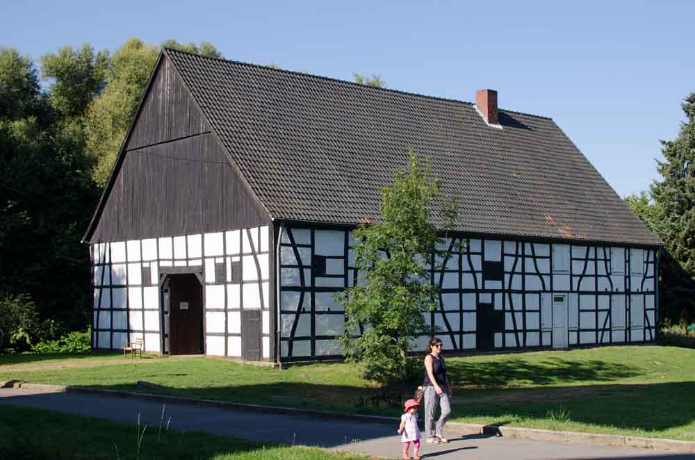 Personen laufen vor dem Bauerhausmuseum entlang
