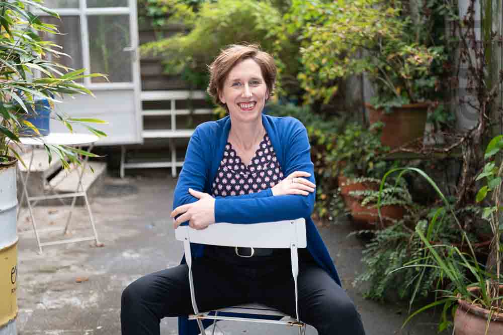 Judith Weber sitzt im Garten auf einem Stuhl
