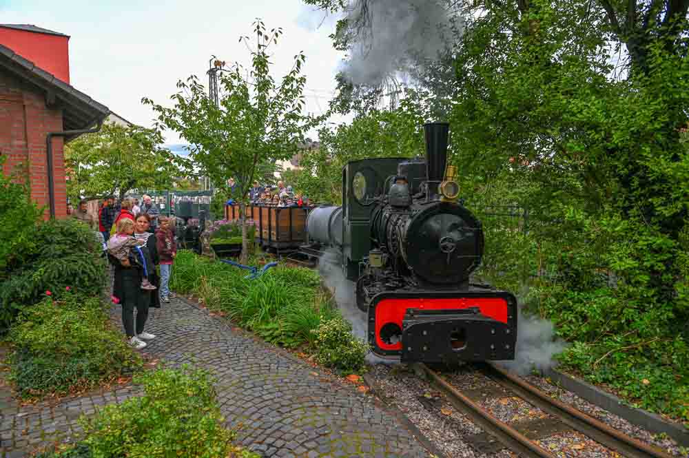 Menschen fahren mit der Dampflok auf dem Gelände des Museum Großauheim