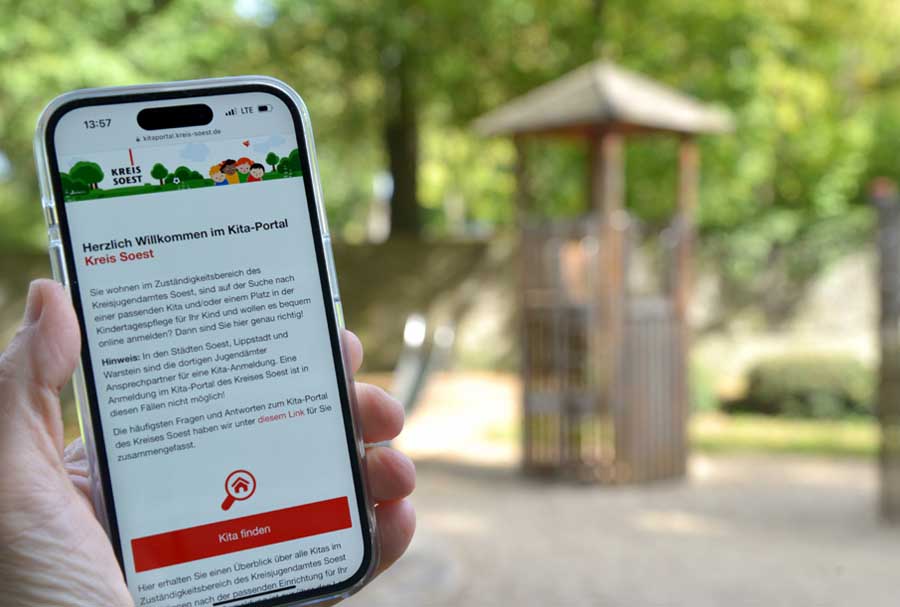 Person hält Handy mit geöffneter Kita-App