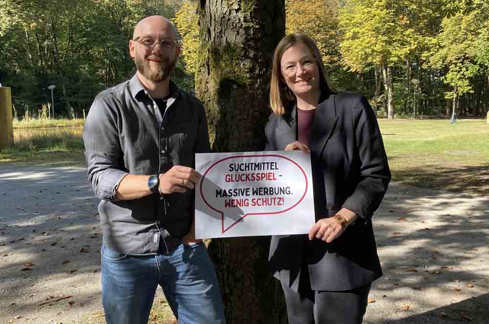 Zwei Personen werben mit Plakat für den Aktionstag gegen Glücksspielsucht