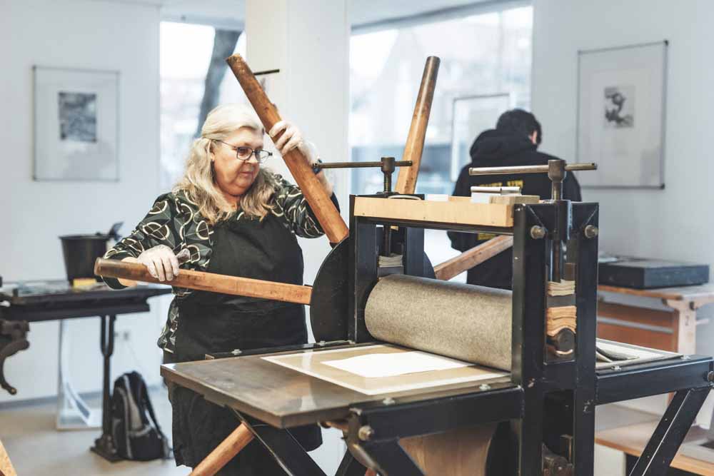 Frau bedient Druckmaschine