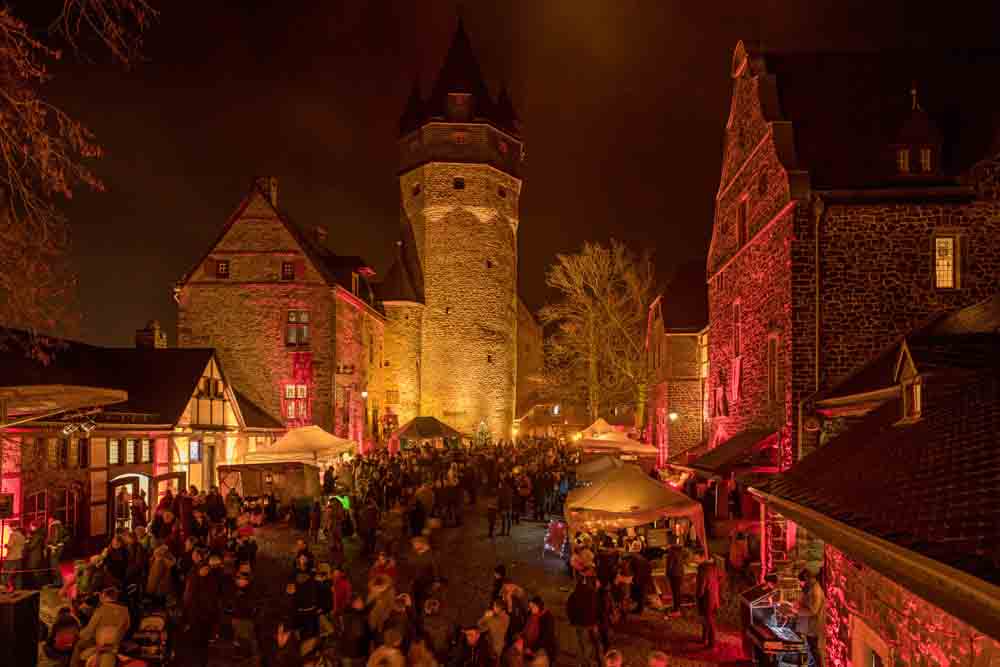 Menschen auf der abendlich beleuchteten Burg Altena