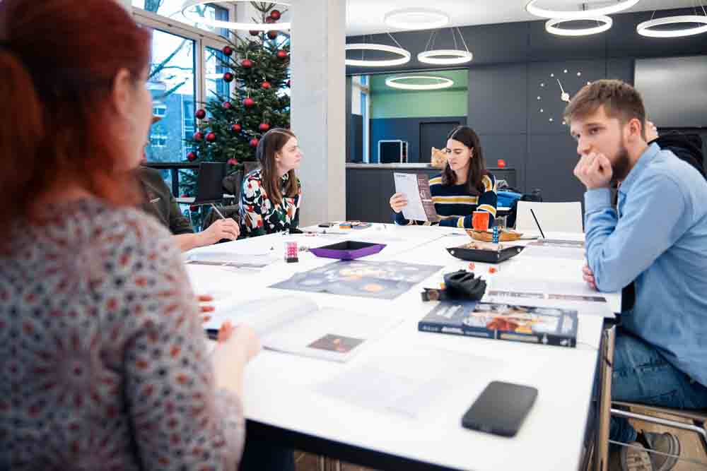 Pen-&-Paper-Gruppe sitzt an einem Tisch