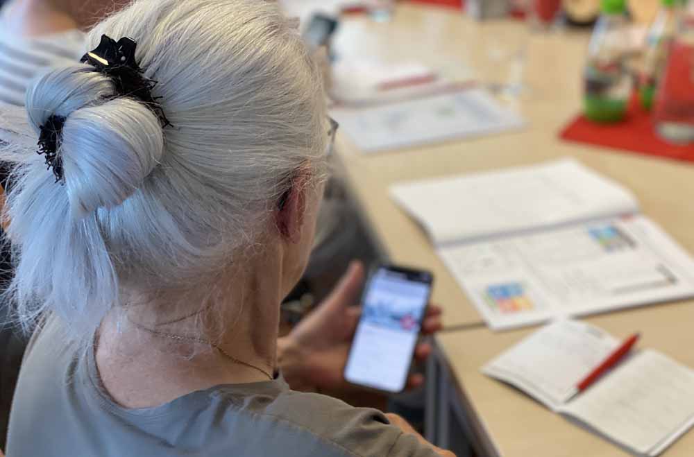 Ältere Dame schaut auf ihr Smartphone
