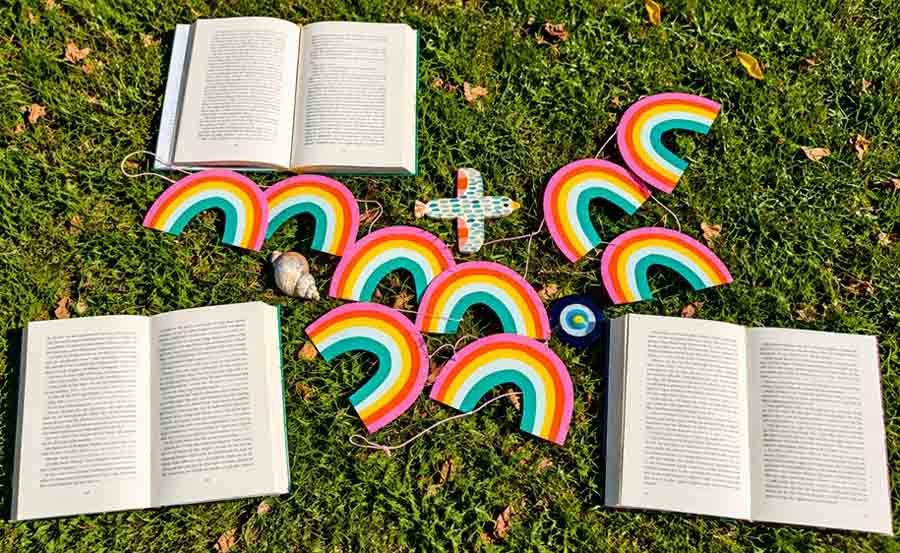 Bücher und Regenbögen liegen auf einer Wiese