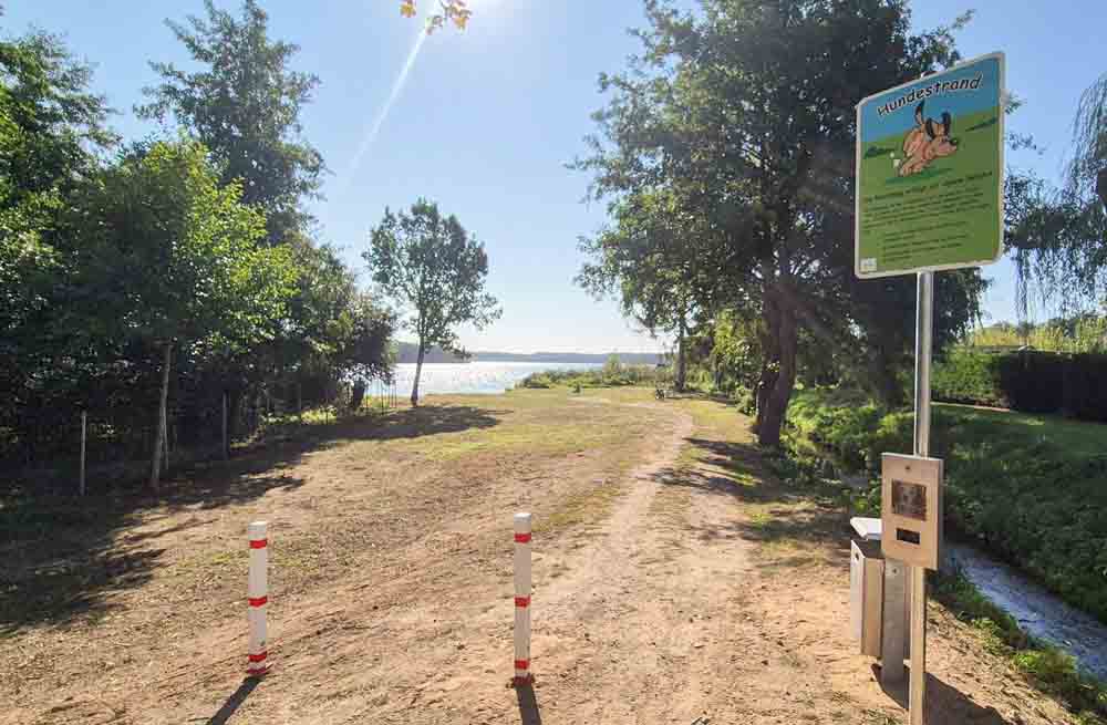 Blick auf den Eingang zum Hundestrand mit Schild